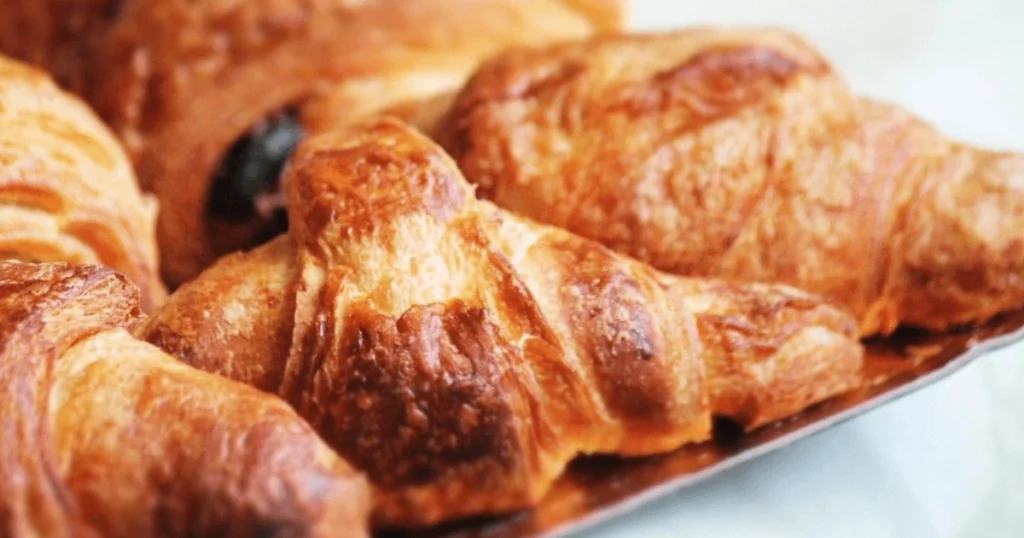 Golden, flaky Gipfeli pastries on a plate, freshly baked with buttery layers, perfect for breakfast or brunch.