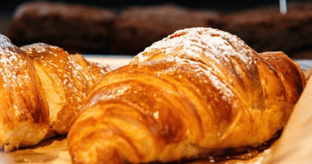Golden, flaky Gipfeli pastries on a plate, freshly baked with buttery layers, perfect for breakfast or brunch.