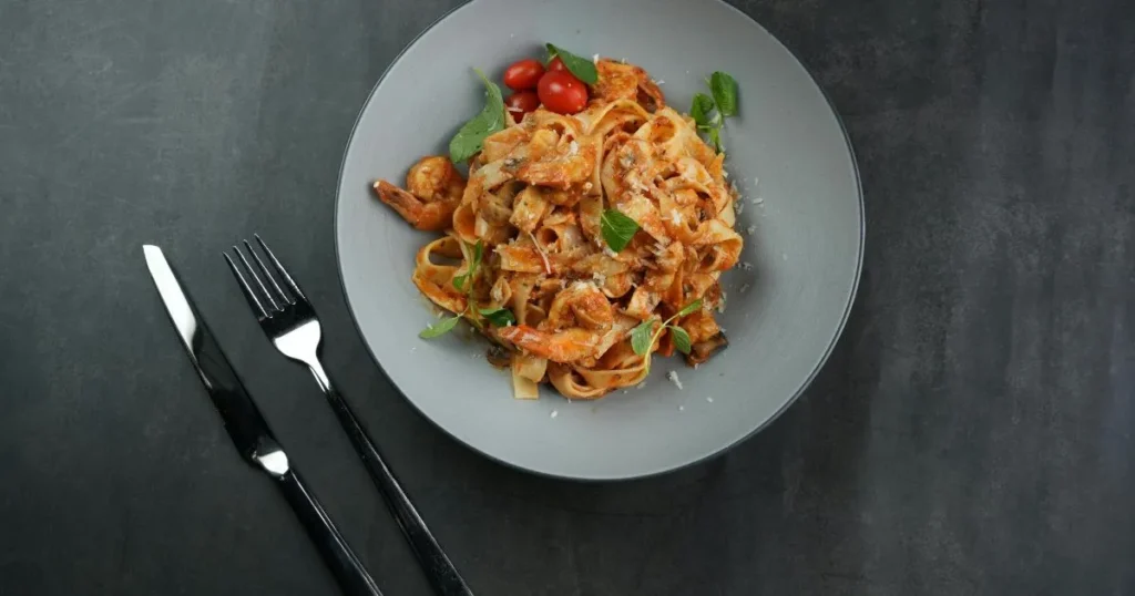 Tossing lobster pasta with creamy sauce for Ramadan iftar
