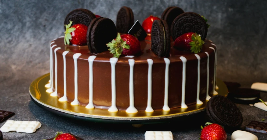 spreading buttercream frosting on homemade birthday cake with spatula