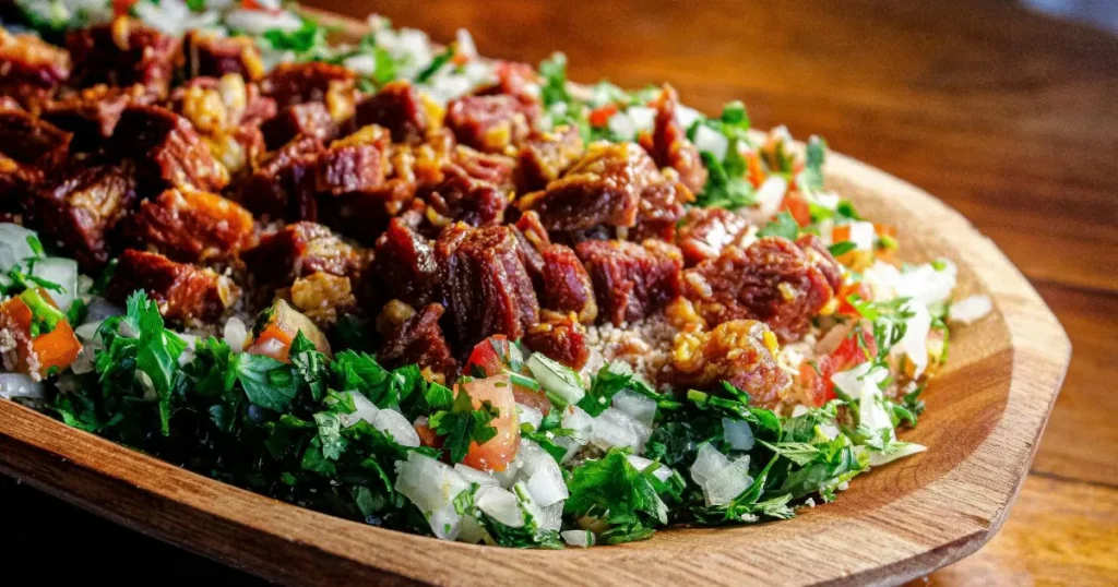 One-pan beef cooking in gravy beside cooked white rice.