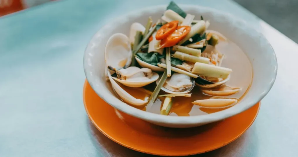 Close-up of thick peanut sauce being stirred in a bowl, showing its creamy consistency and glossy finish.