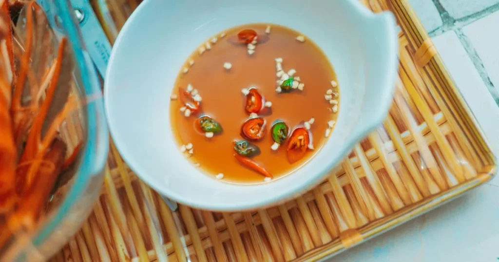 Fresh Vietnamese spring rolls being dipped into a rich peanut sauce, highlighting texture and color contrast.
