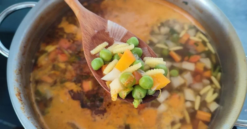 A homemade pot of low sodium chicken noodle soup filled with chicken, noodles, carrots, celery, and fresh parsley.