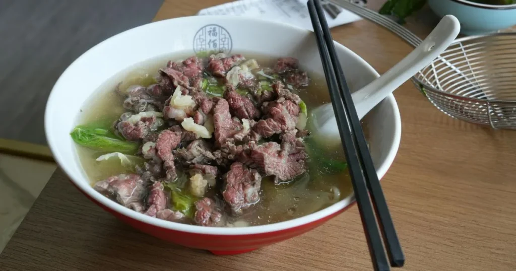 Quick beef soup cooking in a large pot with vegetables and beef bones simmering in broth.