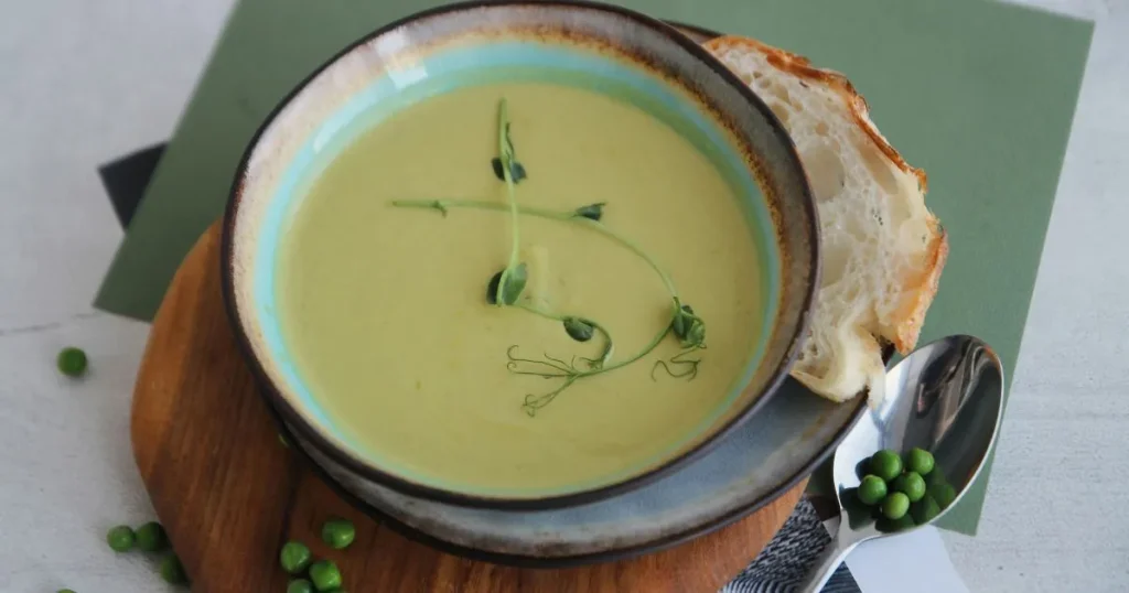 A hot bowl of gluten free chicken soup with chicken pieces, carrots, celery, and fresh herbs.