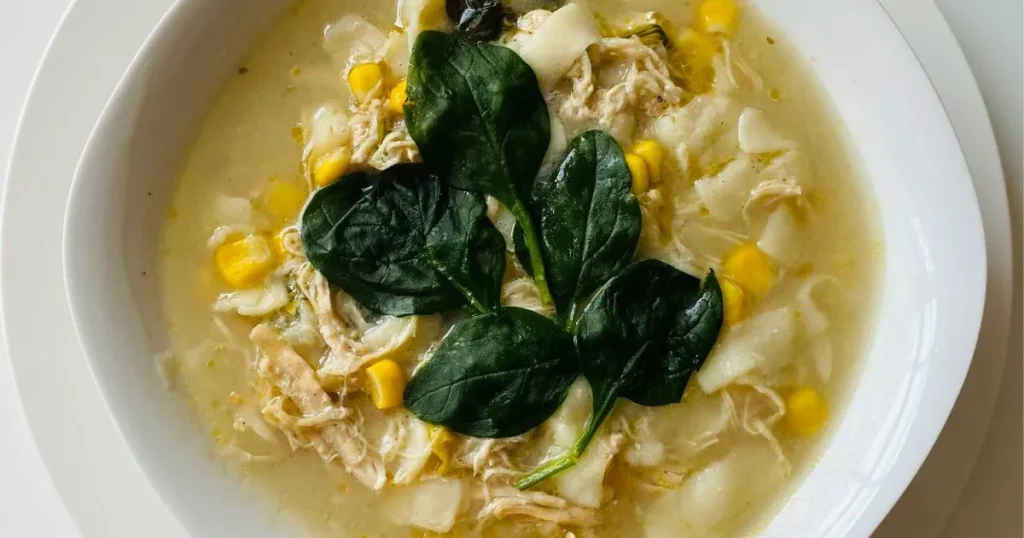A steaming bowl of gluten free chicken soup with carrots, celery, and shredded chicken in a warm broth.
