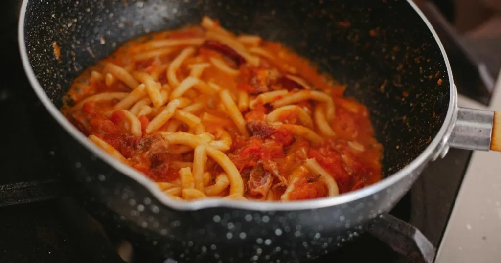 A creamy bowl of casarecce pasta coated in garlic parmesan sauce with fresh basil garnish.