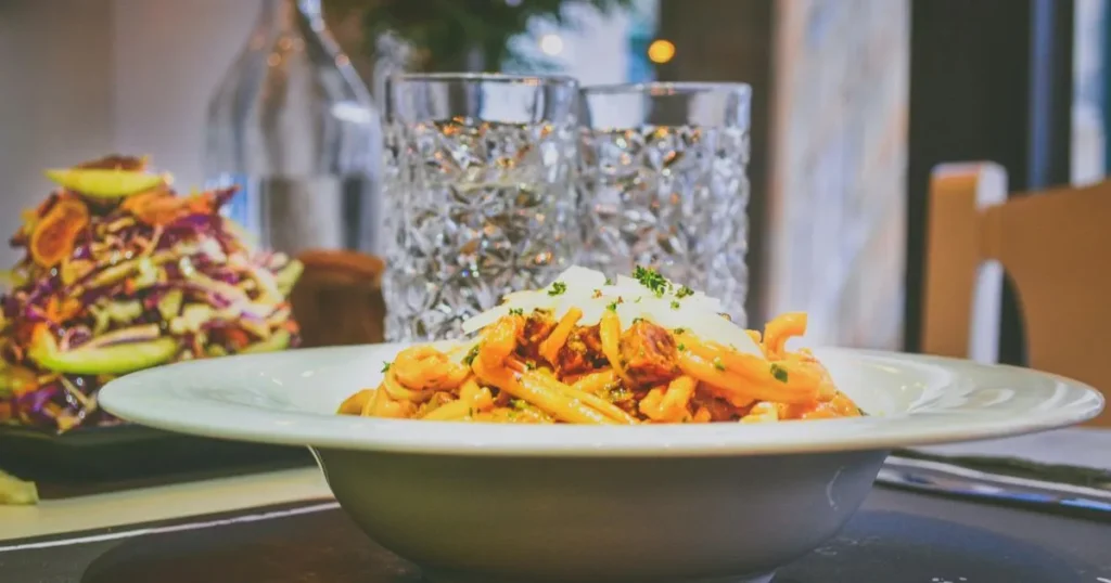 Elegant serving of creamy casarecce pasta topped with parmesan and cracked black pepper.