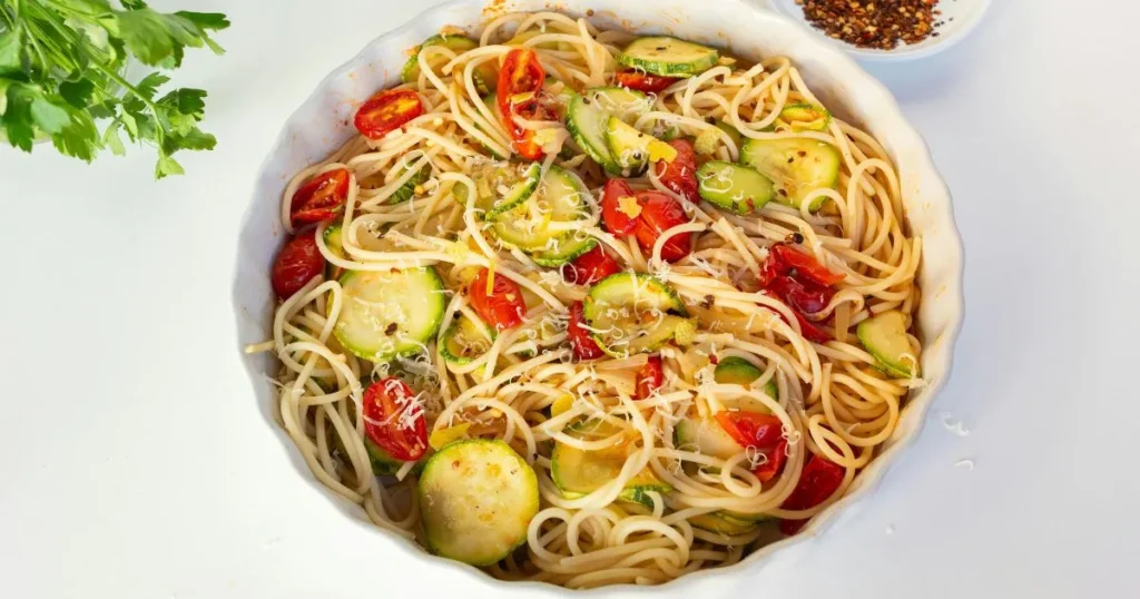 Elegant plating of spaghettini pasta with olive oil and parmesan.