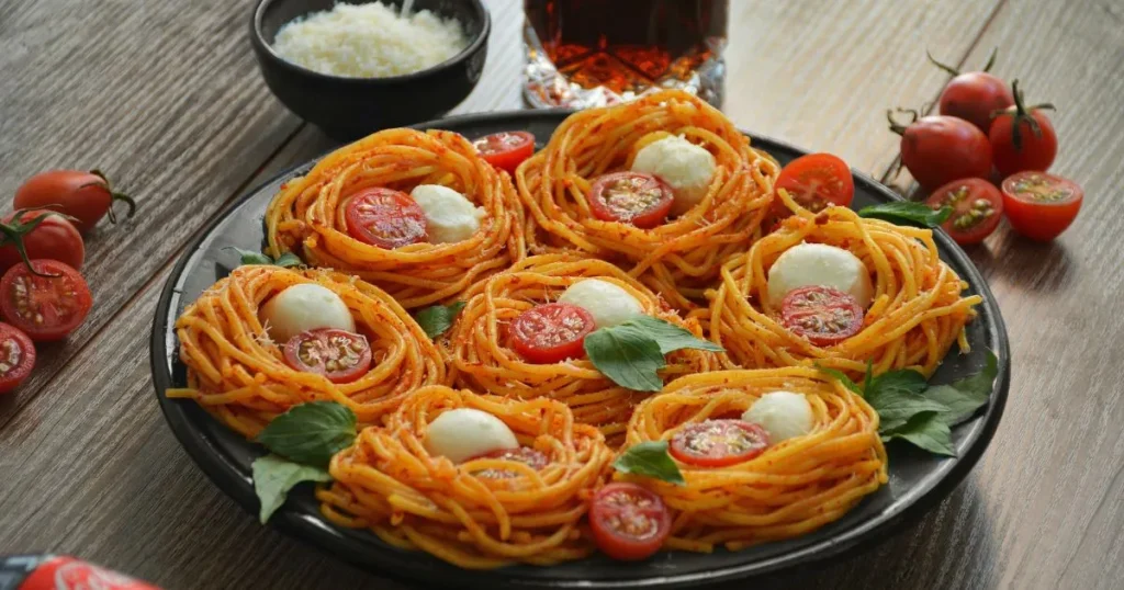 Steaming bowl of spaghettini pasta with garlic and parmesan cheese.