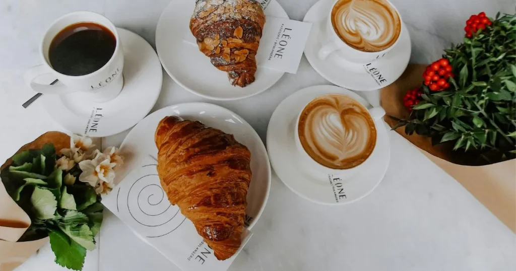 Warm Italian croissants with espresso coffee, mascarpone filling, and fresh berries served on a breakfast table.
