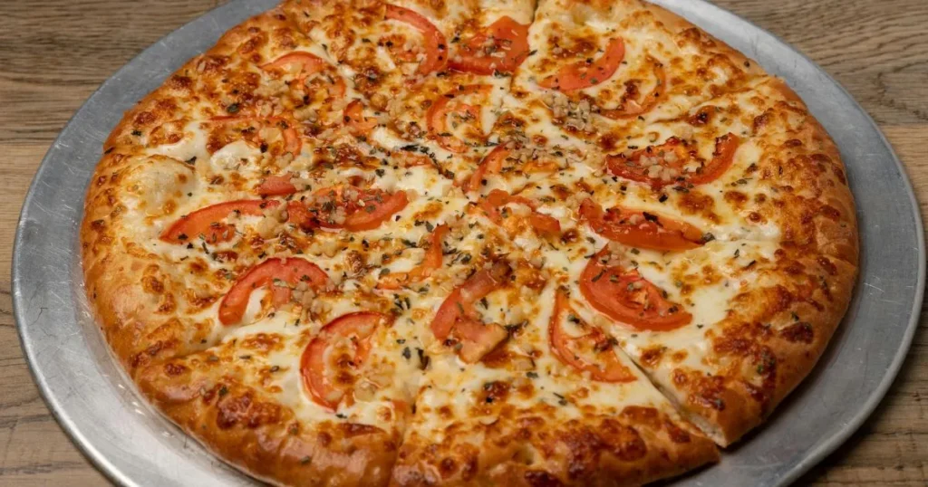 Warm breakfast pizza with melted cheese and scrambled eggs on a crispy crust.