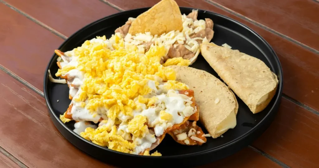 Homemade chilaquiles topped with Cotija cheese, crema, and sliced avocado.